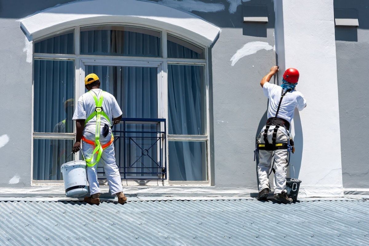 Professional painters applying exterior coating to commercial building in South Africa